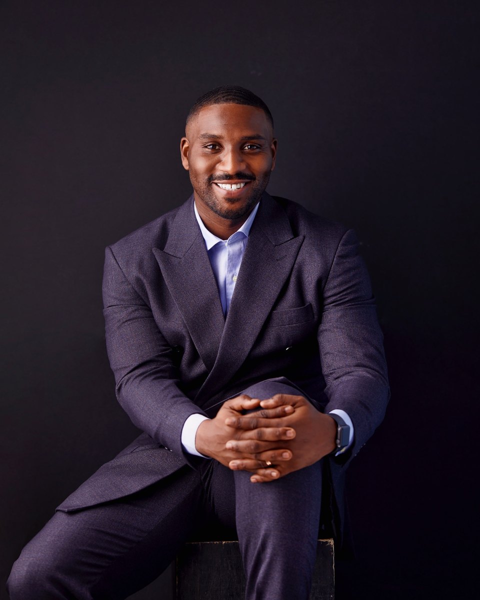 Julian Owusu, Group Chairman of B57, seated and smiling against a dark background.